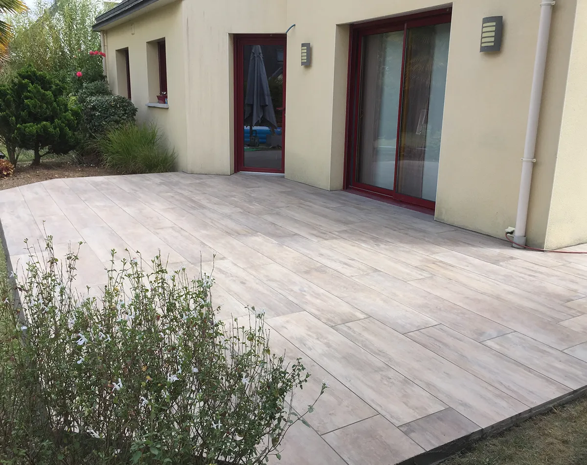 Terrasse à l'arrière d'une maison donnant sur un jardin arboré